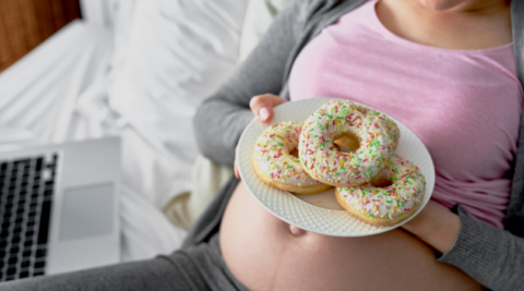 pregnnacy nutrition - pregnant woman about to eat donuts
