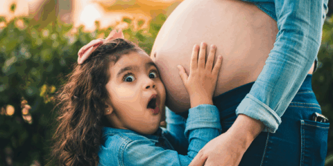 Sibling listening to mommy belly